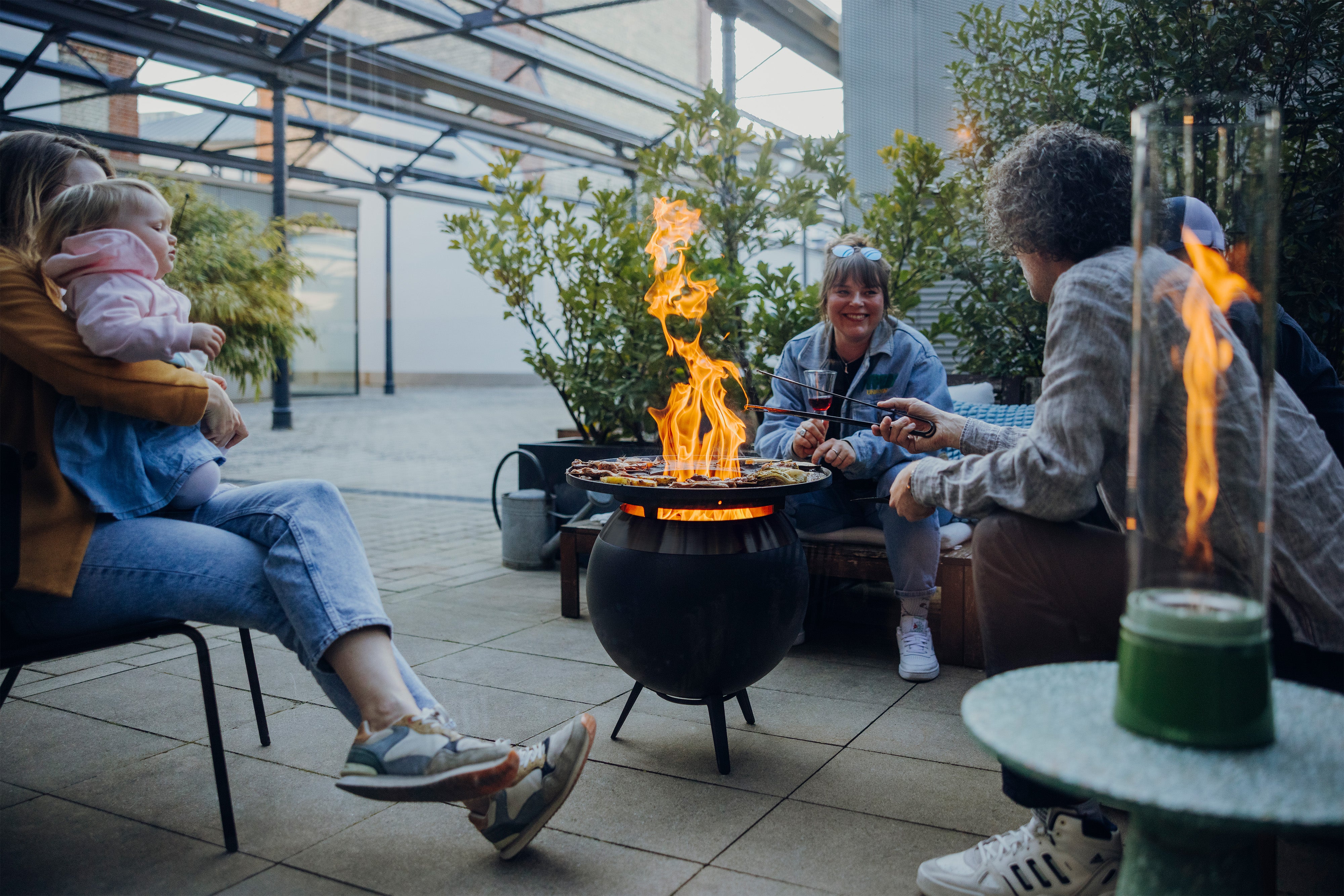 Höfats Moon 45 all Black Plancha Grillset mit niedrigem Fuß in Benutzung mit 3 Leuten