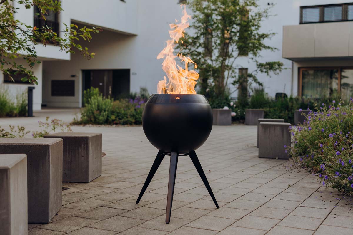 Hoefats Moon 45 all Black Feuerkorb mit hohem Fuß brennend im Innenhof