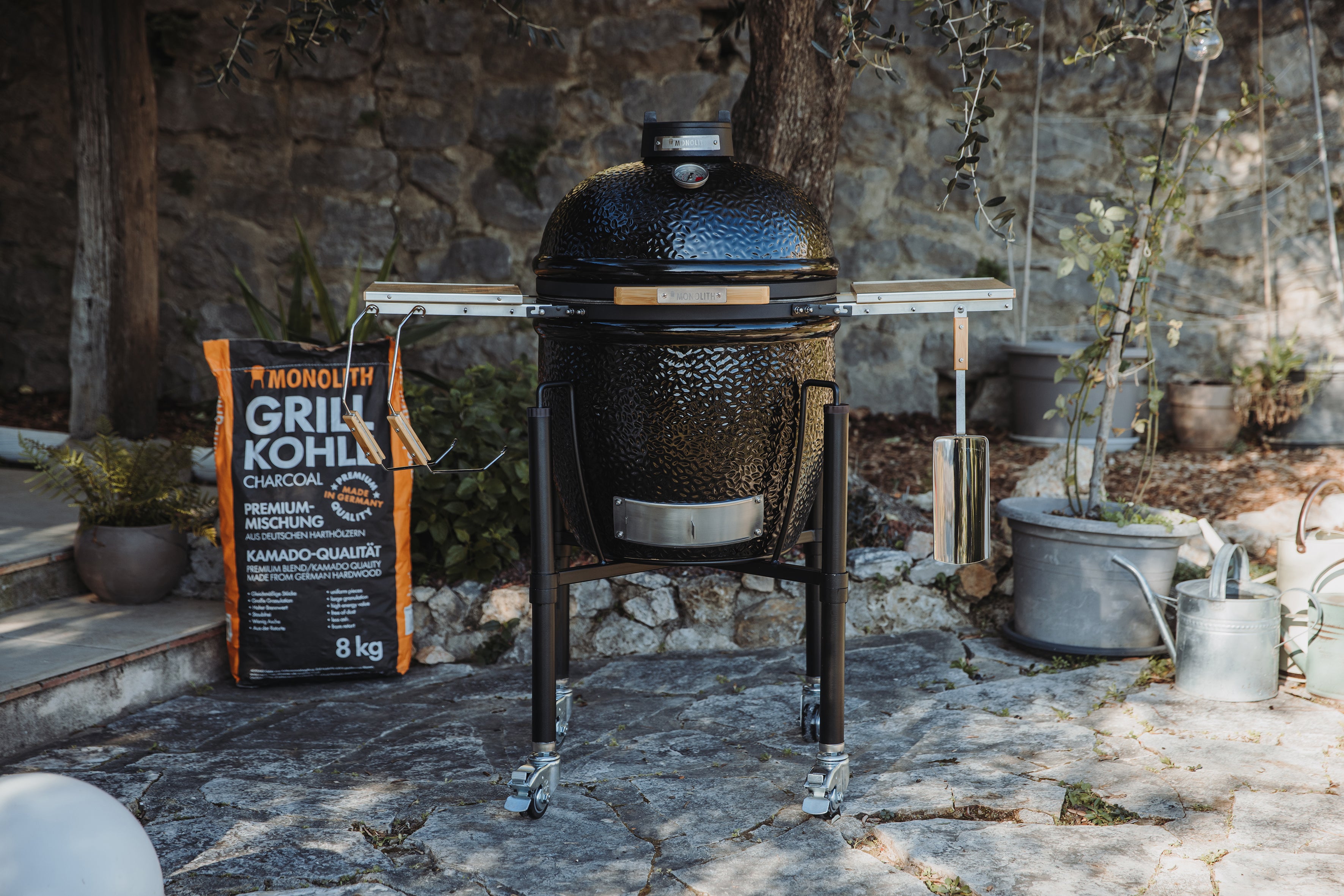 Monolith One.55 Kamado-Grill Frontansicht mit Zubehör im Garten